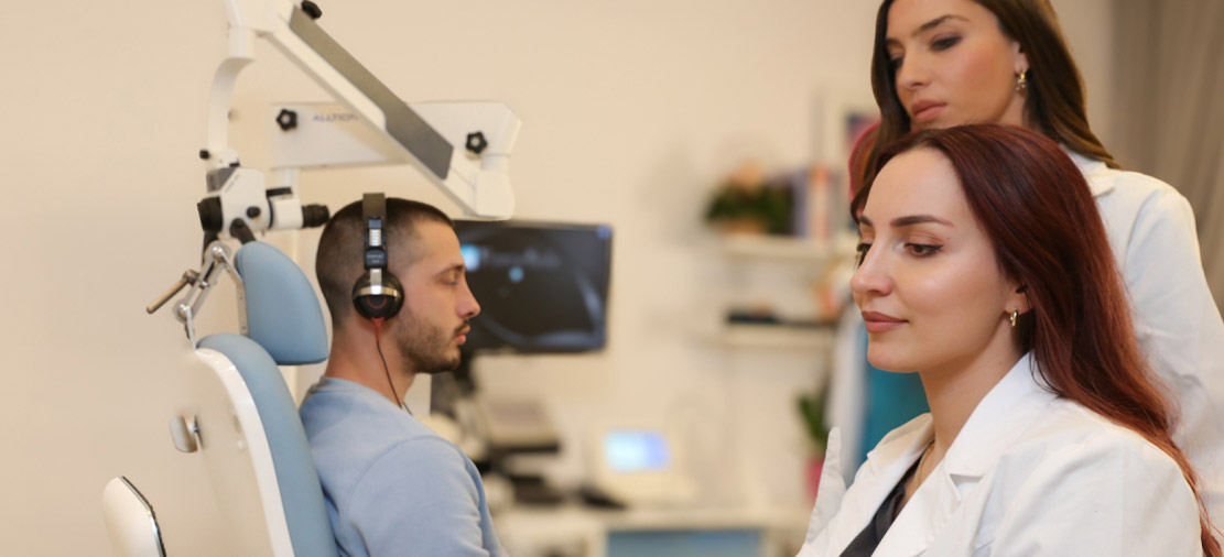 Врачи оториноларингологи осматривают пациента, поскольку у него тиннитус.