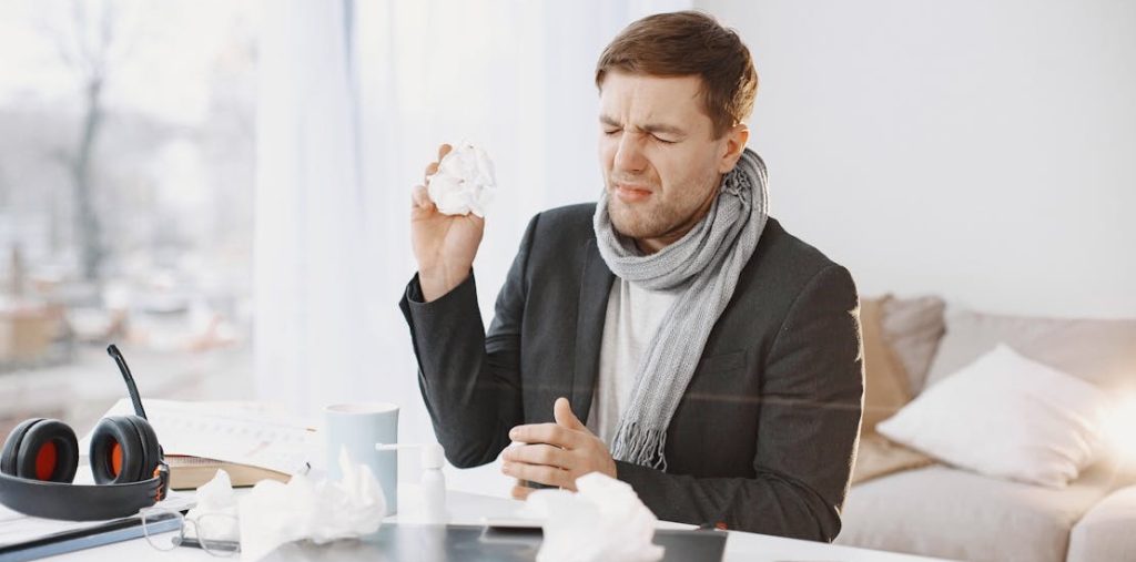 covek drzi papirnu maramicu i pravi grimasu 