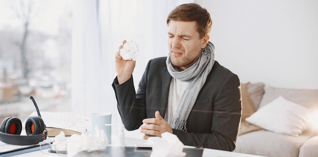 Мужчина держит бумажную салфетку и кривит лицо.