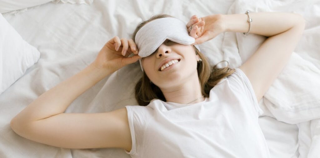 A happy girl is lying in bed.