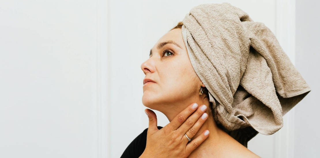 žena sa peškirom na glavi koja razmišlja da li bi joj skin booster tretman pomogao
