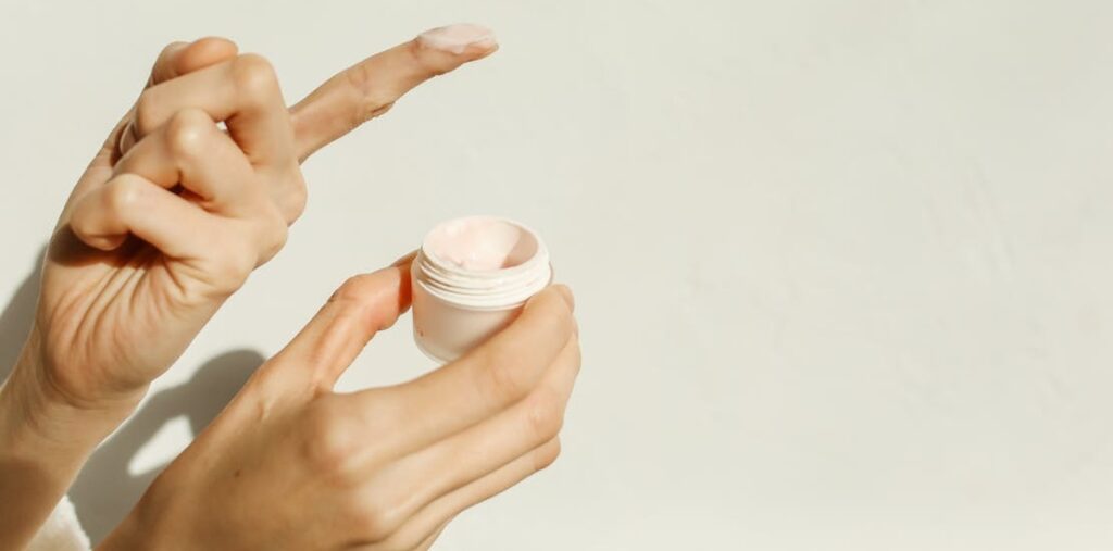 zenska osoba drzi kremu u ruci 
