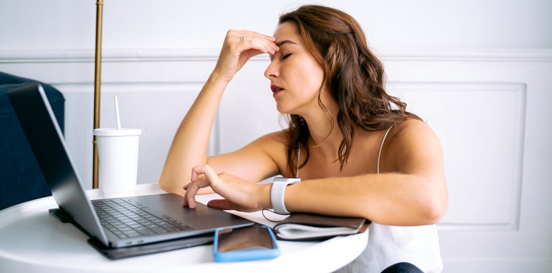 A woman is holding her head.