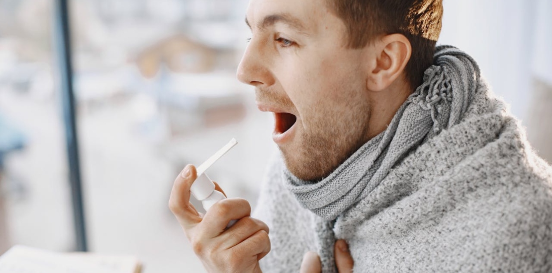 čovek prska sprej u usta jer ima laringitis 