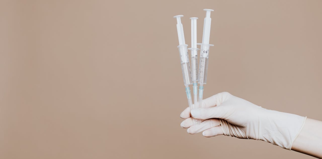 A person holding three syringes