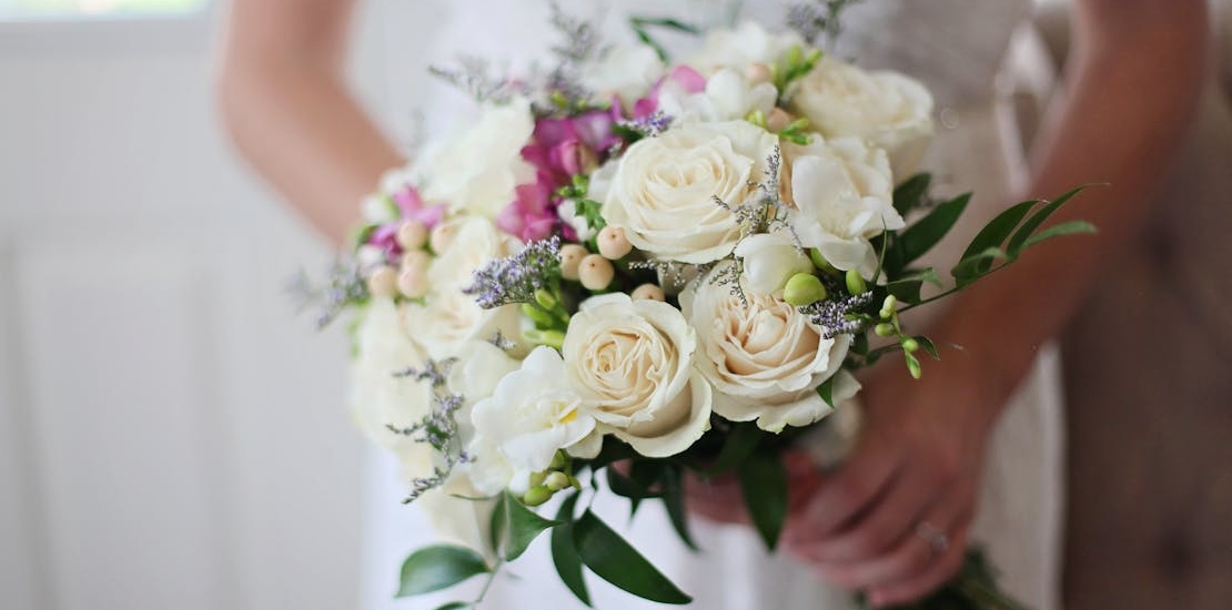 Молодая девушка держит букет в руке