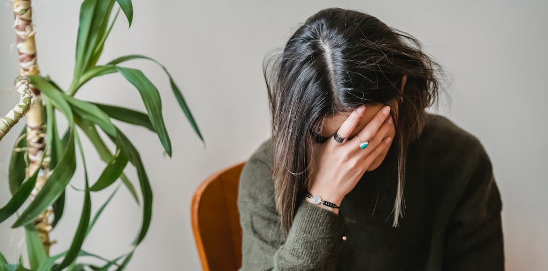 Osoba oseća glavobolju, što može biti znak problema sa sinusima