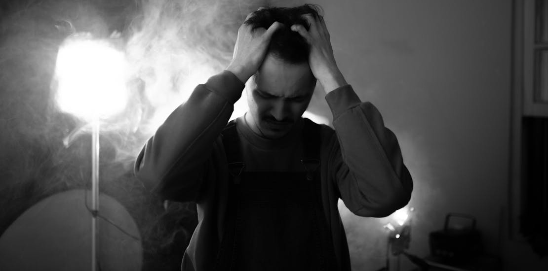 Čovek koji se drži za glavu.