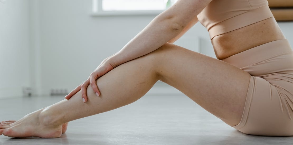 zena sedi na podu sa rukama na kolenima