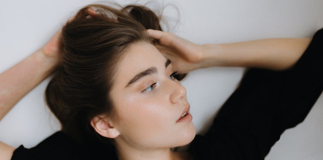 Mlada žena sa glatkom kožom leži i razmislja o  Juvelook i Lenisna tretmanima