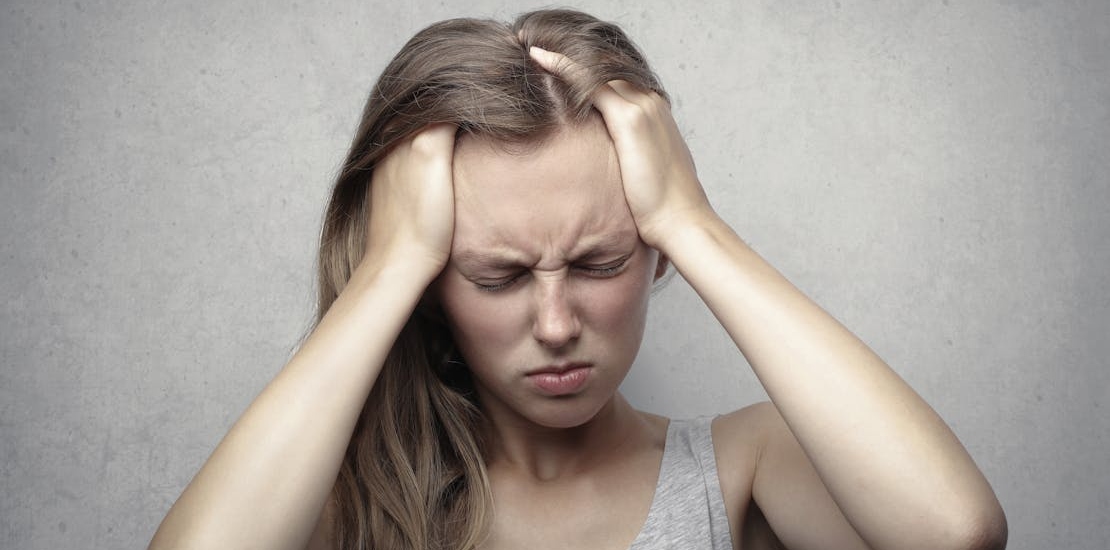 Žena drži sebe za glavu.