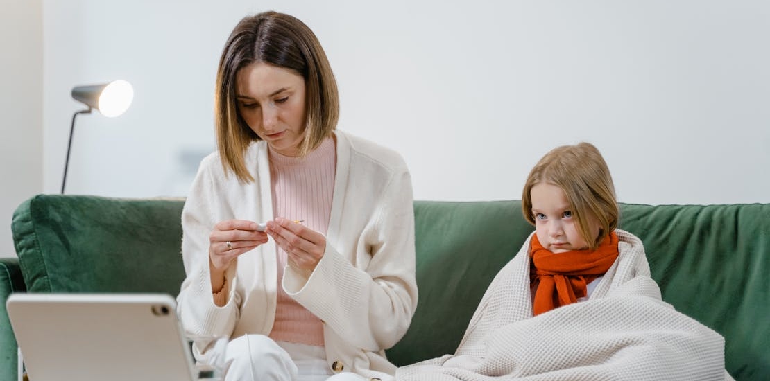 A mother is taking her child's temperature.