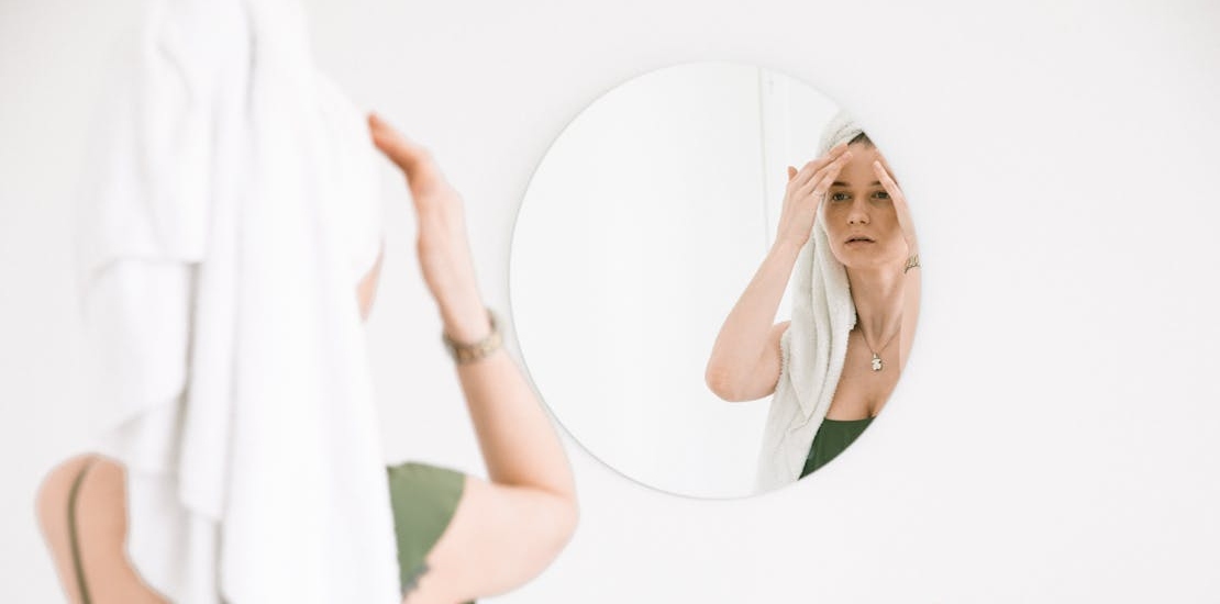 zena se gleda u ugledalu i pita se sta je bolje mezoterapija ili hijaluronski fileri