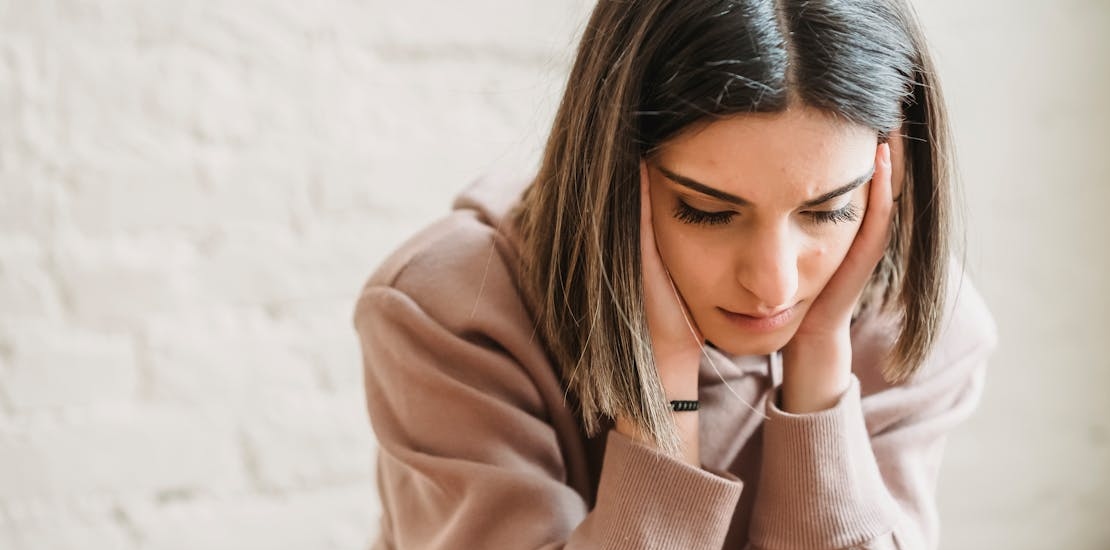 A woman appears concerned as she experiences pressure in her ears.
