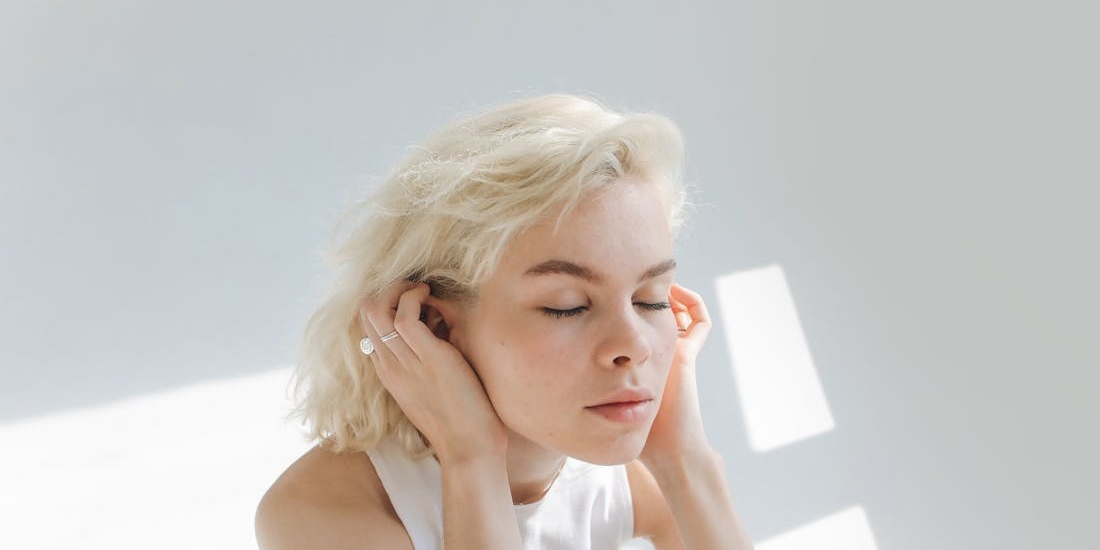 A person with closed eyes feels pain due to an ear pain.