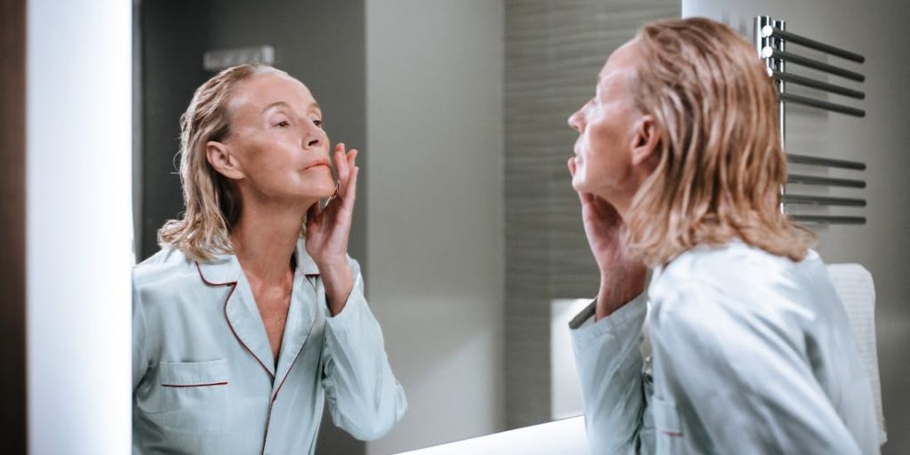 Žena nanosi kremu kao deo podmlađivanja kože nakon 50. godine