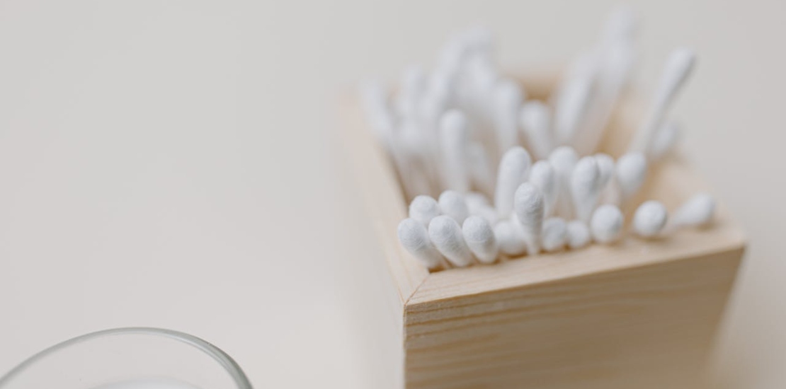 štapići za uši u drvenoj posudi 