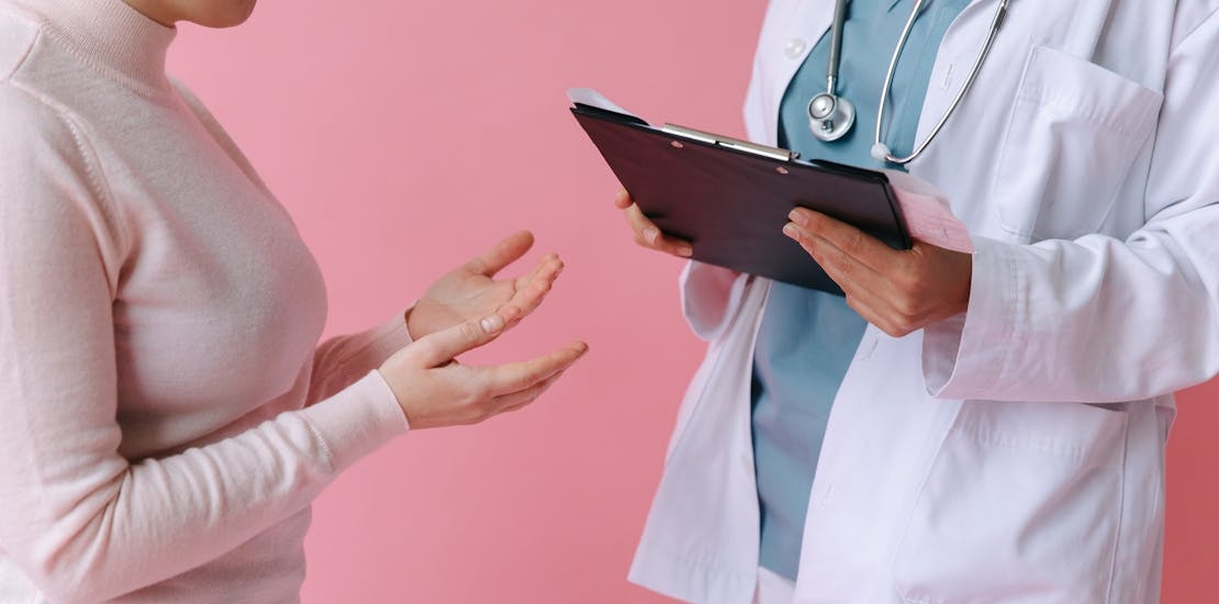 A woman talks to her doctor about symptoms indicating ear pressure.