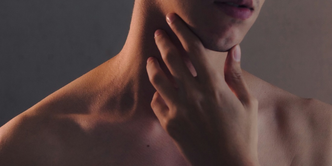 muškarac koji se drži za vrat jer ga boli grlo