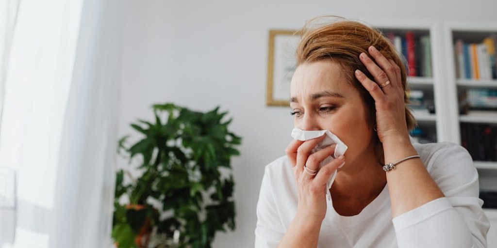 Žena briše nos zbog zapušenosti i osećaja nelagodnost