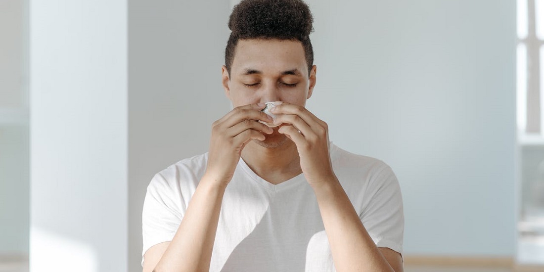 Muškarac koristi papirnu maramicu i zatvara oči