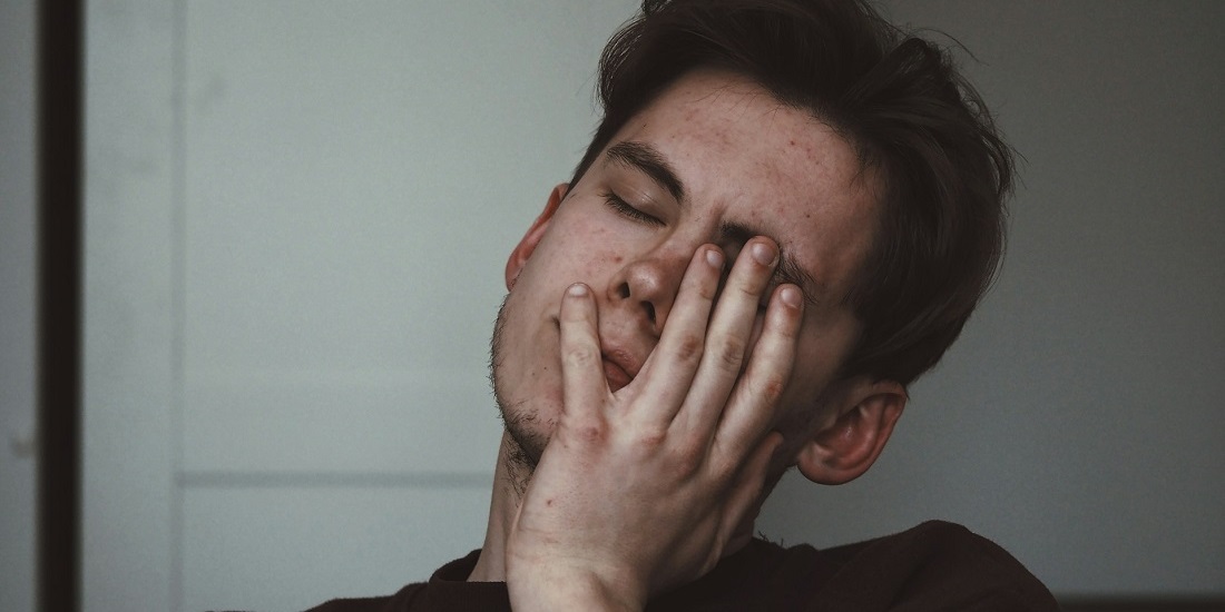 A young man feels dizzy, which may be a sign he needs a preventive ENT check-up.