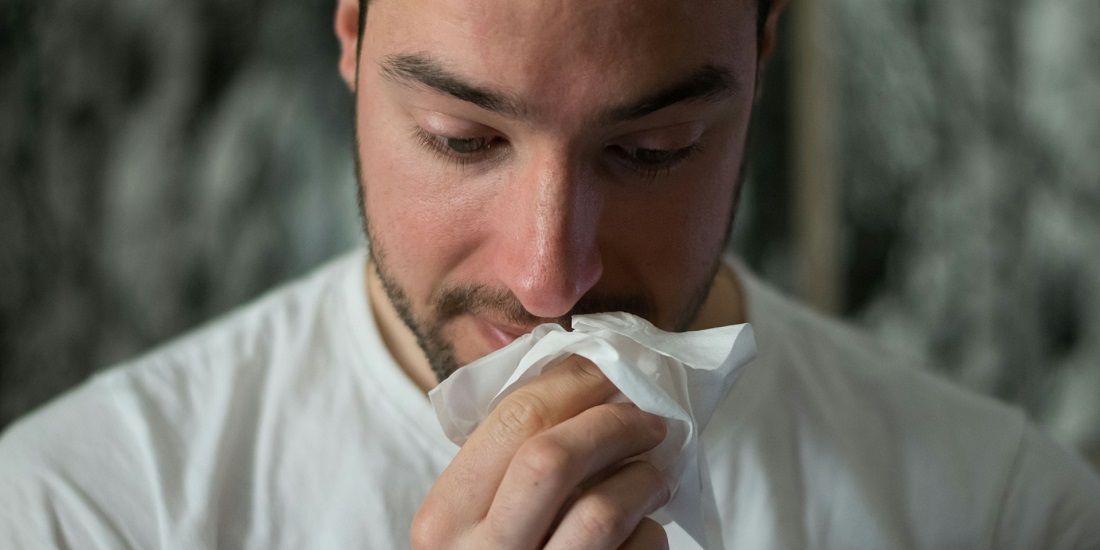 Muškarac sa hroničnim rinitisom briše nos zbog stalnog curenja sekreta.