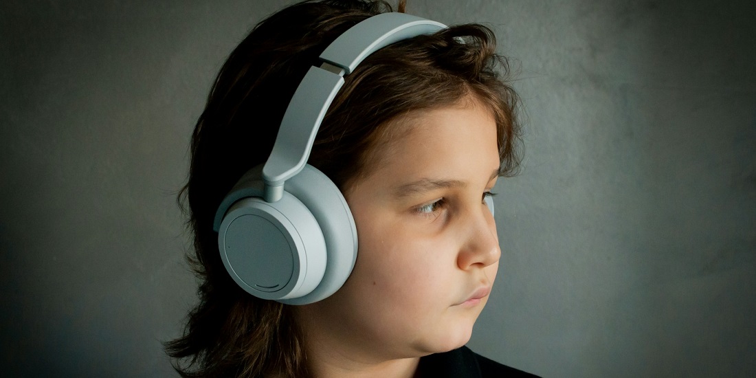 dečak sa slušalicama gleda u stranu 