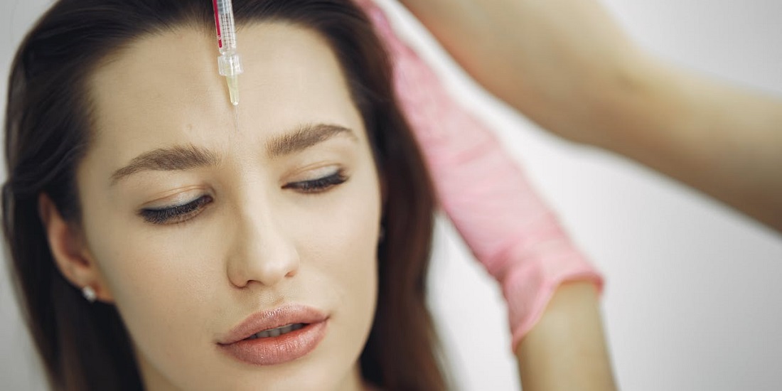 dermatolog pregleda kožu lica pacijenta tokom tretmana.