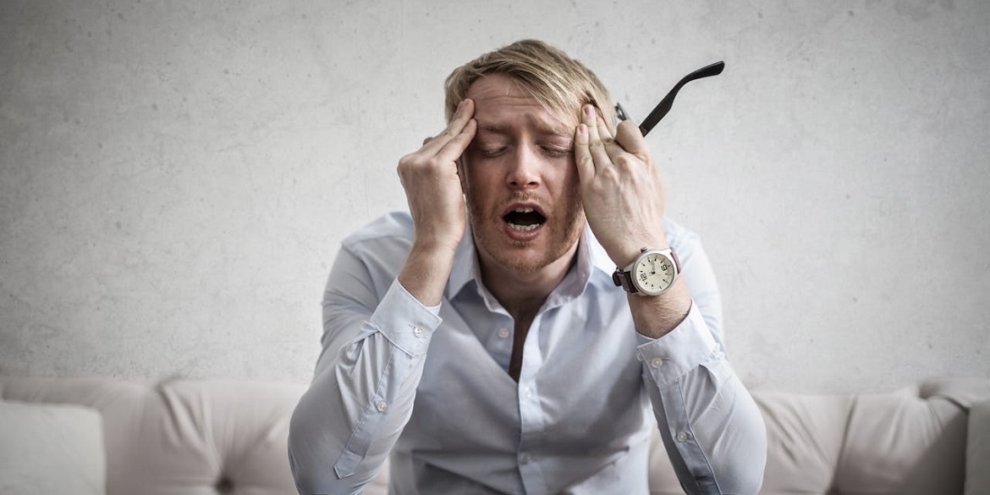 Muškarac sa zatvorenim očima, deluje iscrpljeno i pod stresom.