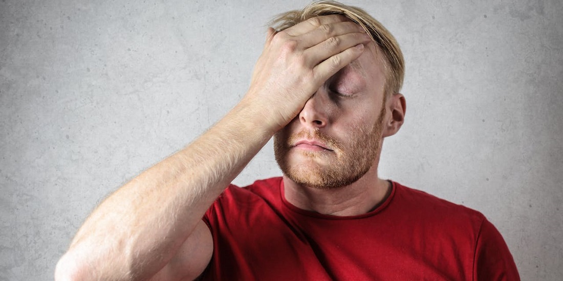 muškarac prekriva lice rukom jer mu problemi sa sinusima utiču na psihu