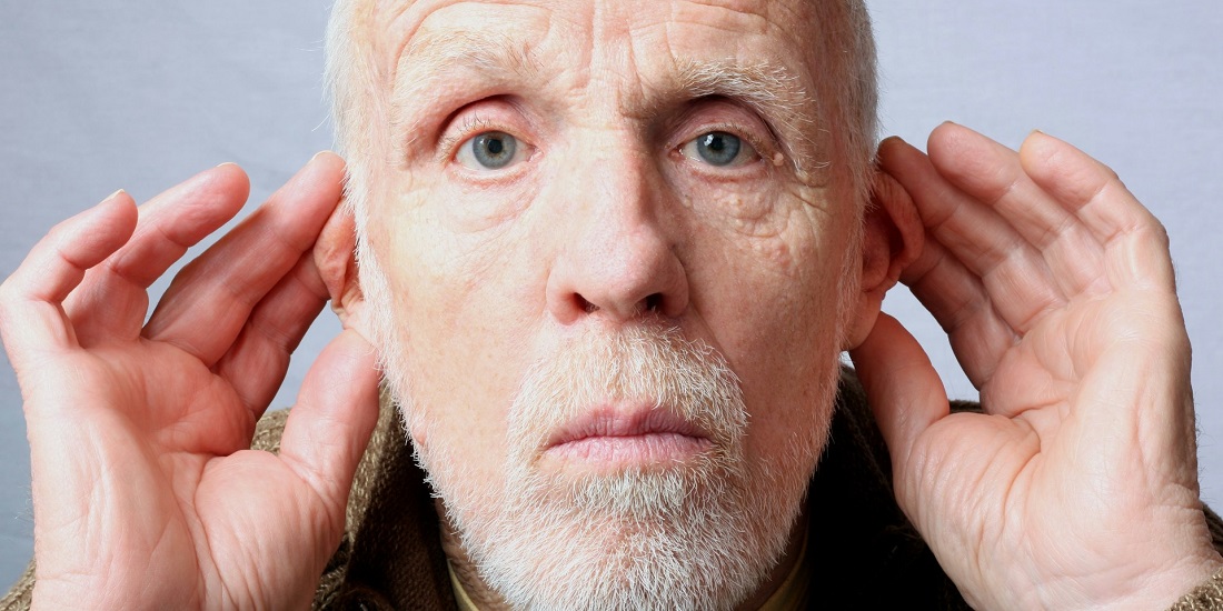 Stariji muškarac koje potrebna audiometrija pokušava da čuje