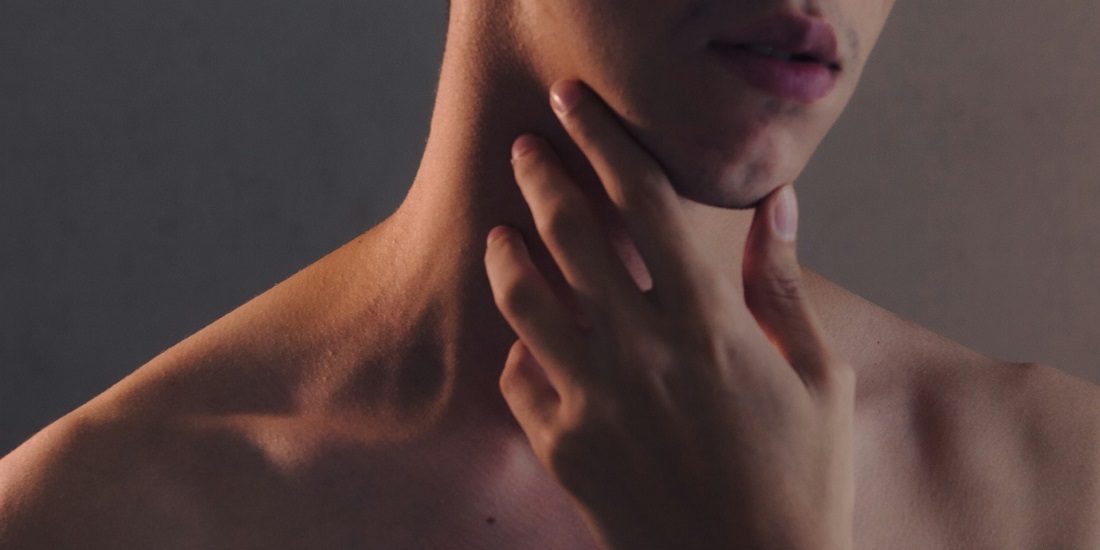 osoba koju boli grlo ujutru sa rukom na vratu 