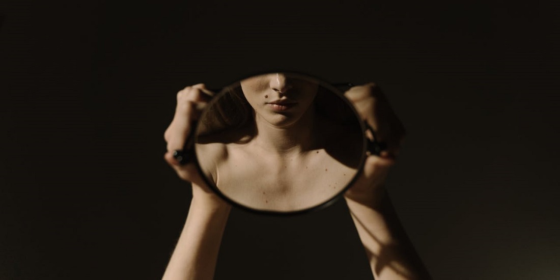 devojka se gleda u ogledalo nakon biopsije