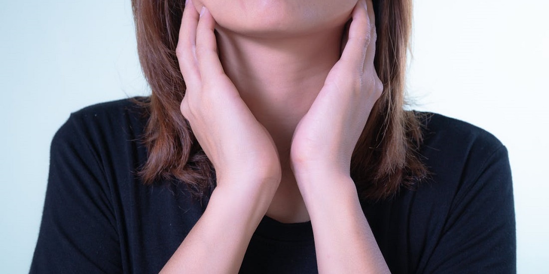 žena se drži za grlo 