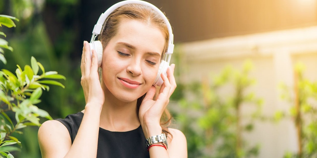 Devojka uživa u muzici na otvorenom prostoru