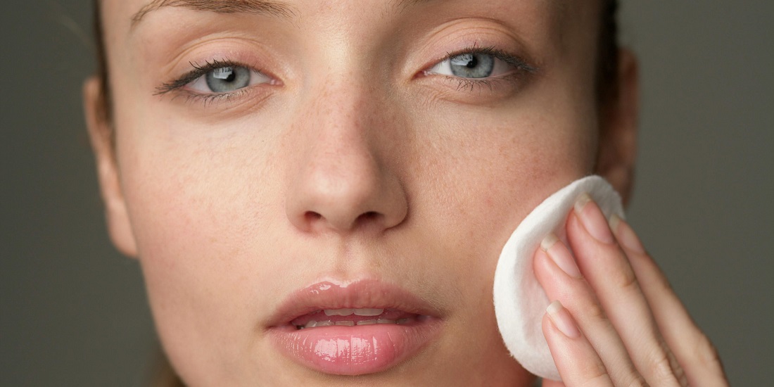 žena čisti lice pamučnim tuferom