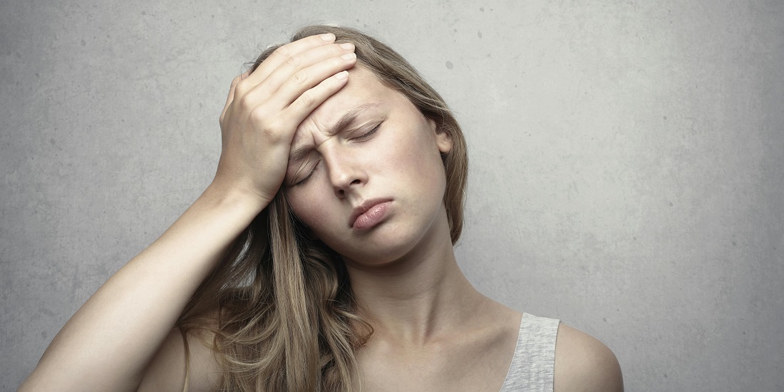 Mlada žena oseća pritisak i glavobolju u čelu.