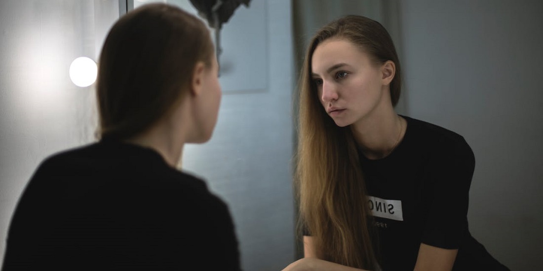 devojka se gleda u ogledalu