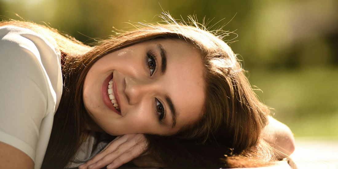 A young person with a wide smile.