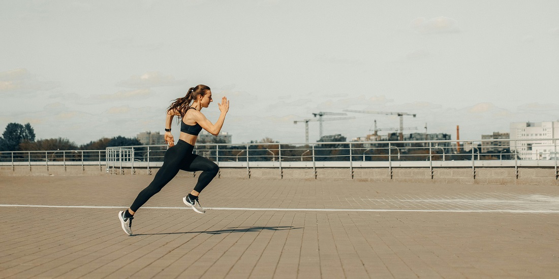 A young woman is running, wondering how can physical activity affect the longevity of aesthetic procedures