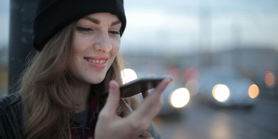 Žena koristi telefon i snima glasovnu poruku, nesvesna kako se glas menja sa godinama.