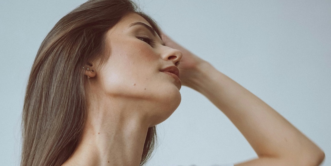 Žena sa naglašenim oblikom vilice, elegantno podiže kosu.