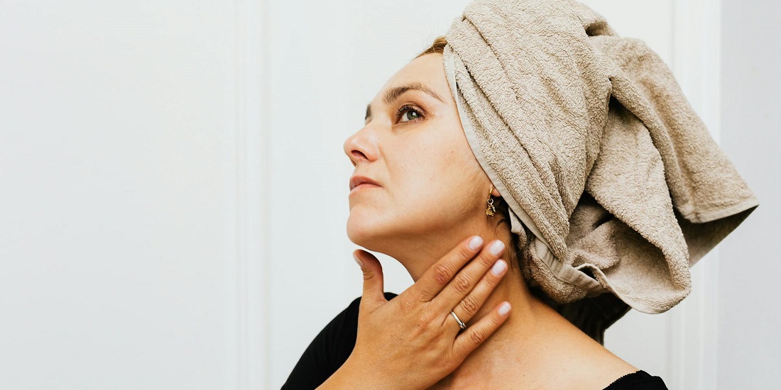 A woman checking her facial skin after her skincare routine.