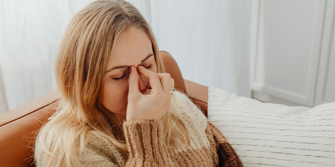 Žena sa prehladom trlja nos zbog iritacije i suvog vazduha.