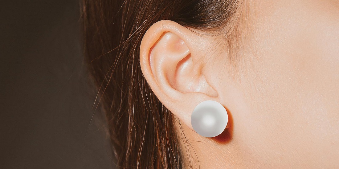 Uho sa bisernom minđušom posle uspešne otoplastike.