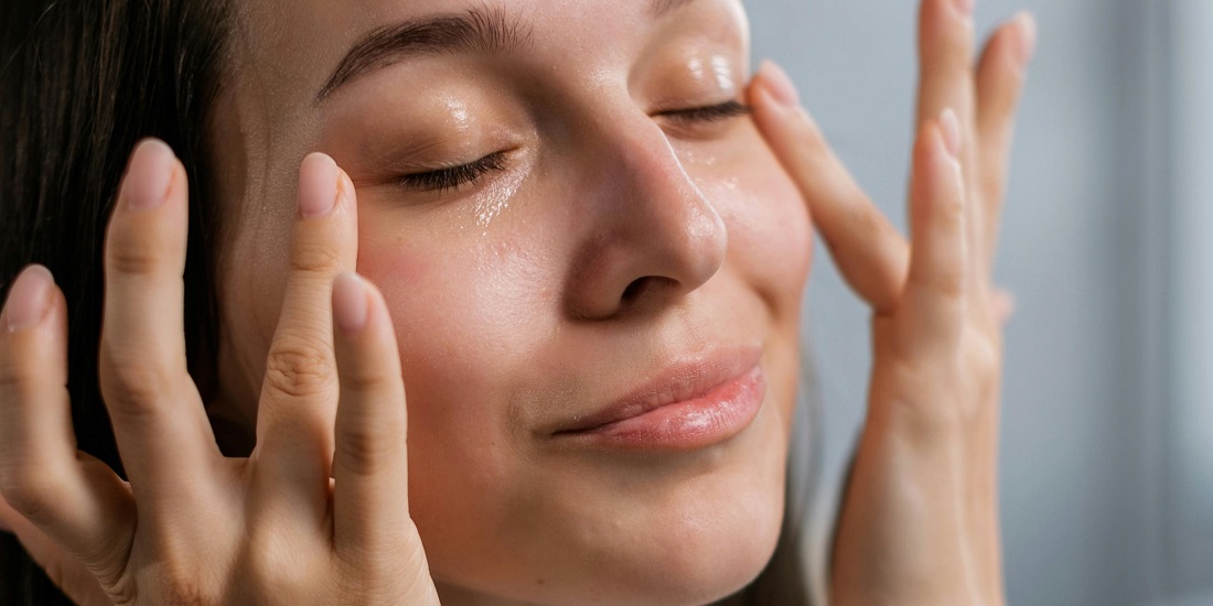 Žena nanosi serum za bolji tonus kože lica