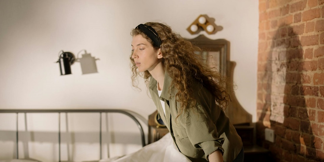 Mlada žena namešta krevet