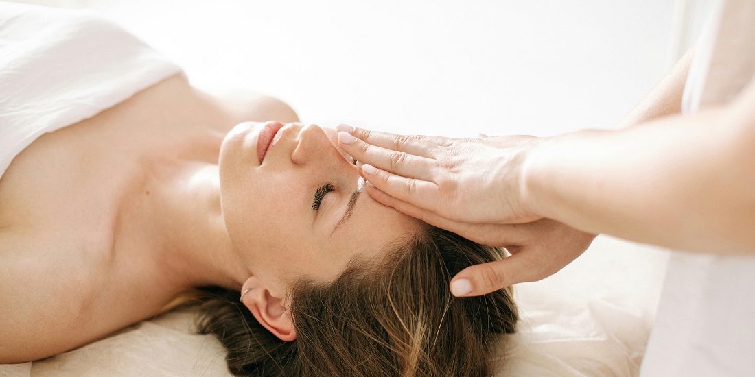 Žena opuštena dok terapeut masira područje čela.