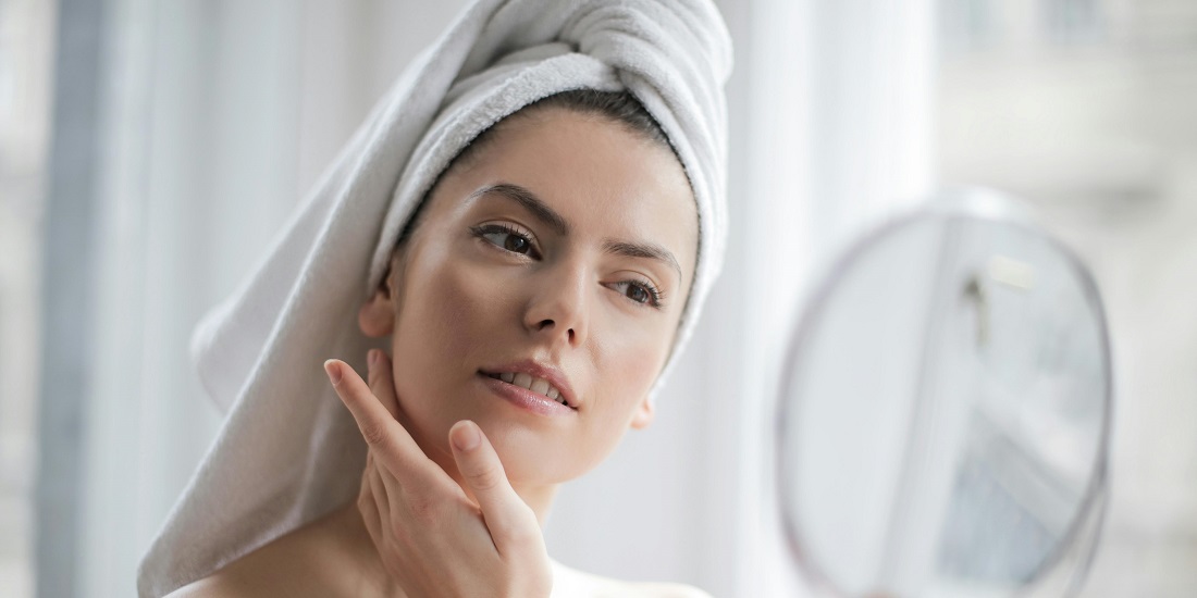 Žena posmatra lice u ogledalu jer joj je potrebna, priprema kože za laserske tretmane